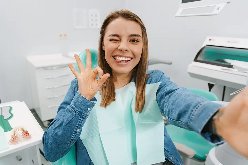 joyful-young-woman-showing-her-sign How Often Should You Visit a Dentist: The Short Answer