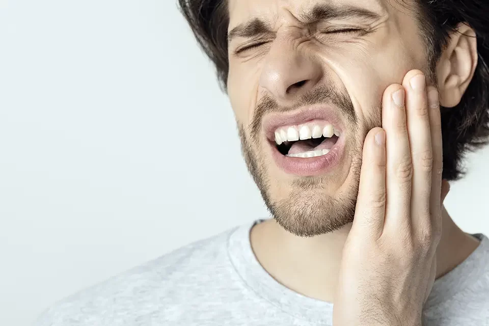 man-feeling-pain-holding-cheek-with-hand Emergency Dental Care Guide: The First Five Minutes (Do This First)